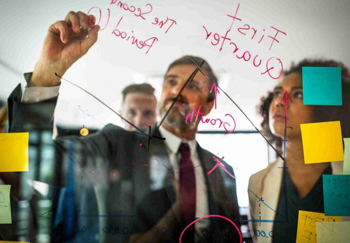 Businesspeople planning on a glass wall