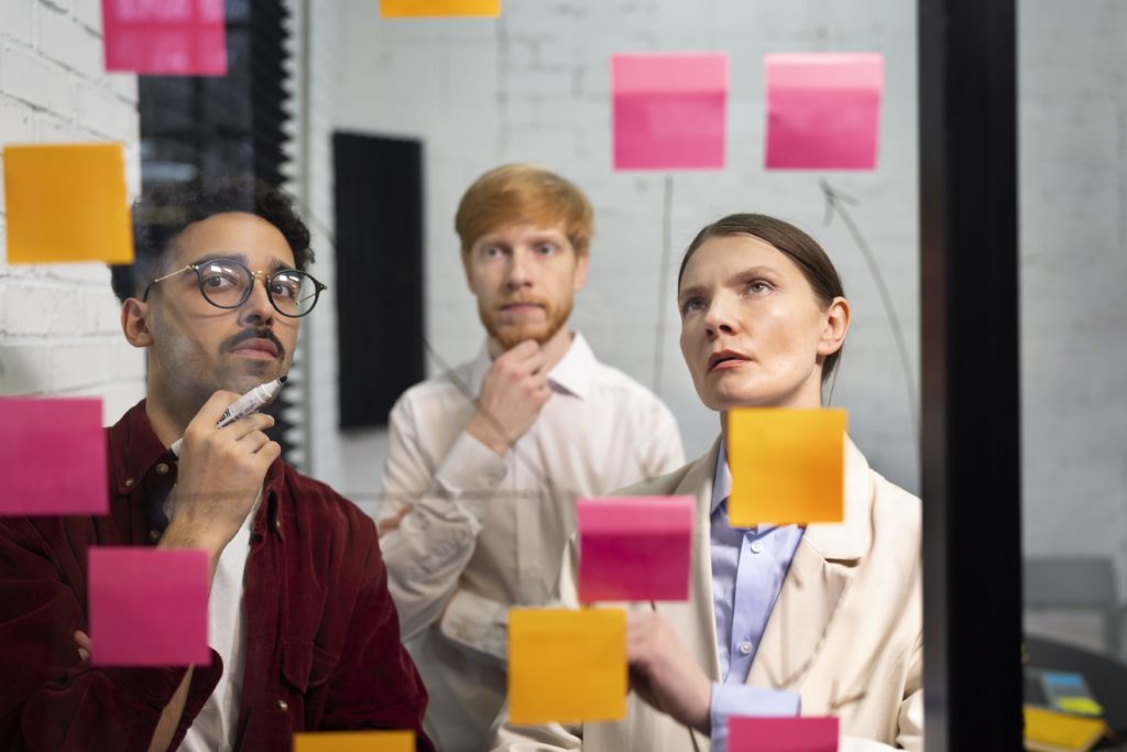 Personnes qui réfléchissent face à un tableau