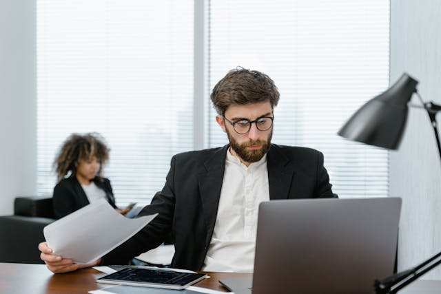 man sit on a desk working with laptop
